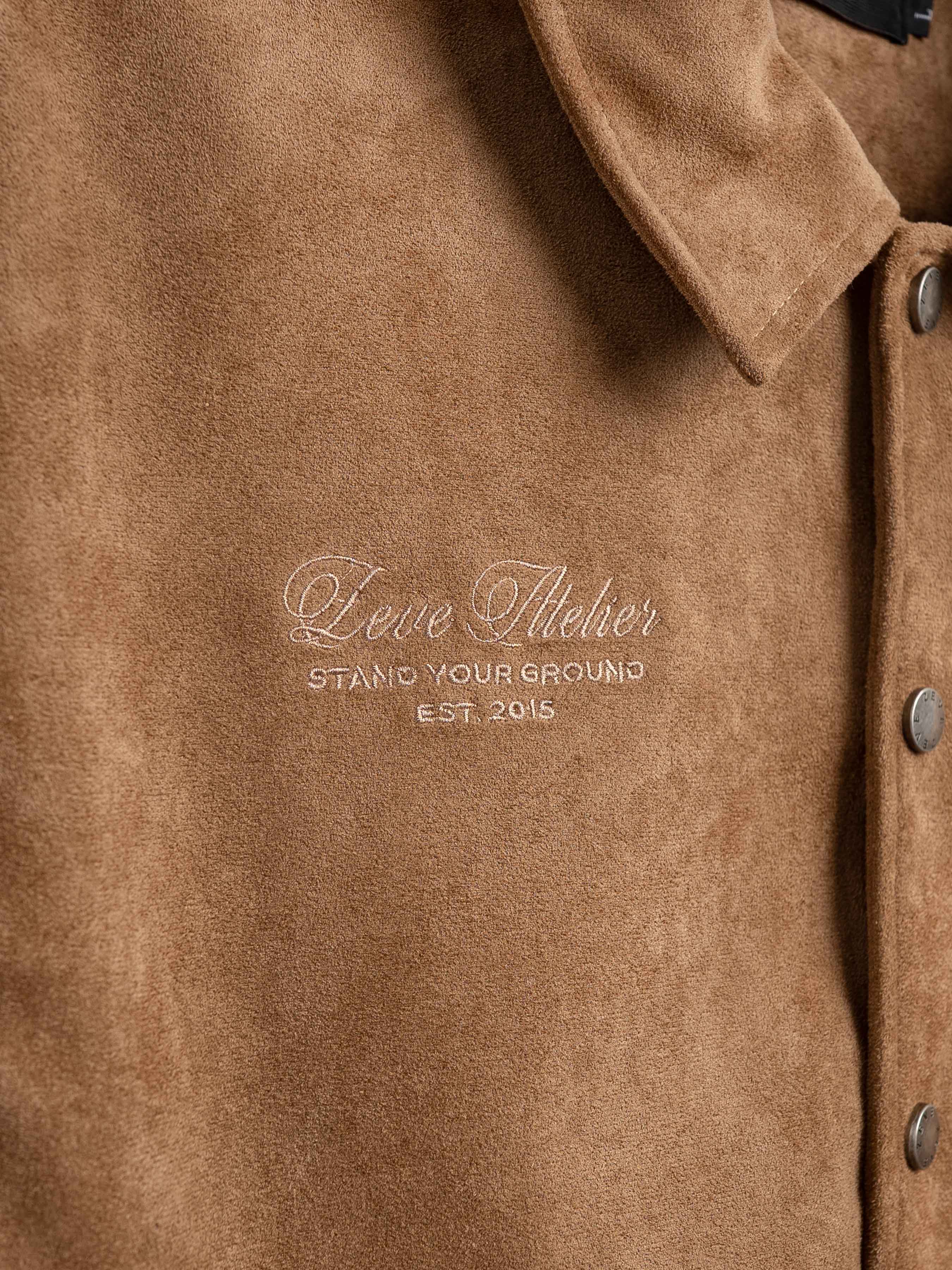 Brown suede men's jacket with embroidered 'Leve Atelier' logo, stylish outerwear for formal or casual wear.