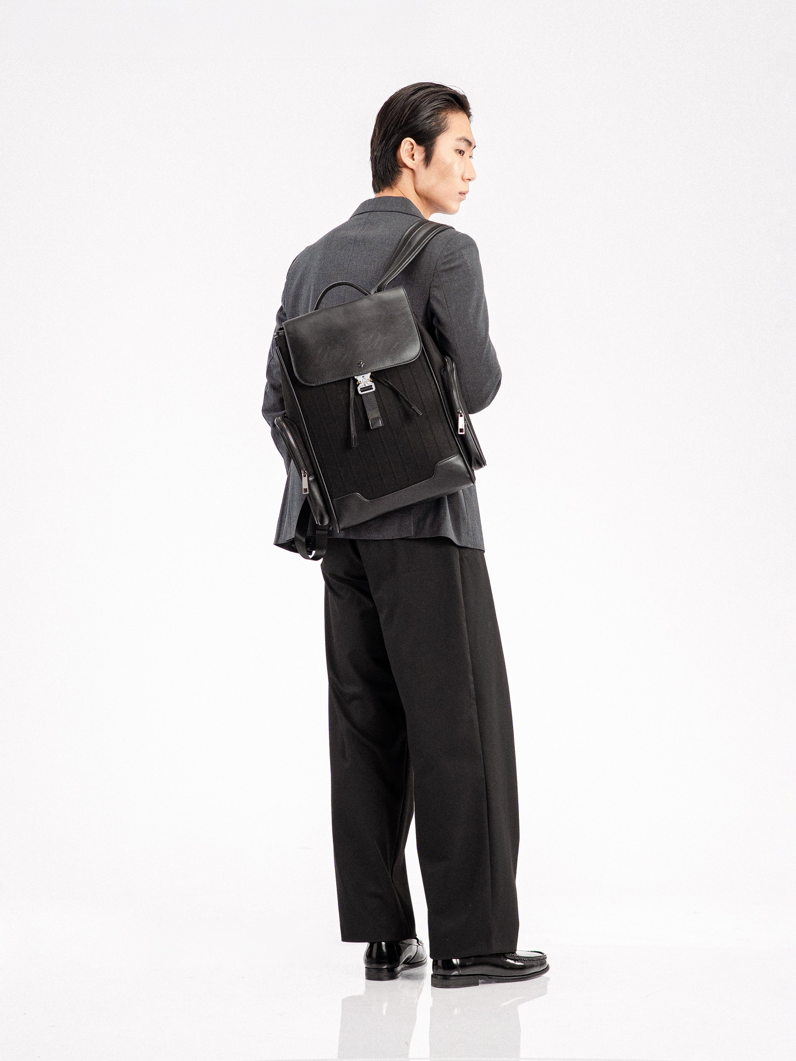 Man in formal suit with black leather backpack, stylish men's apparel and loafers