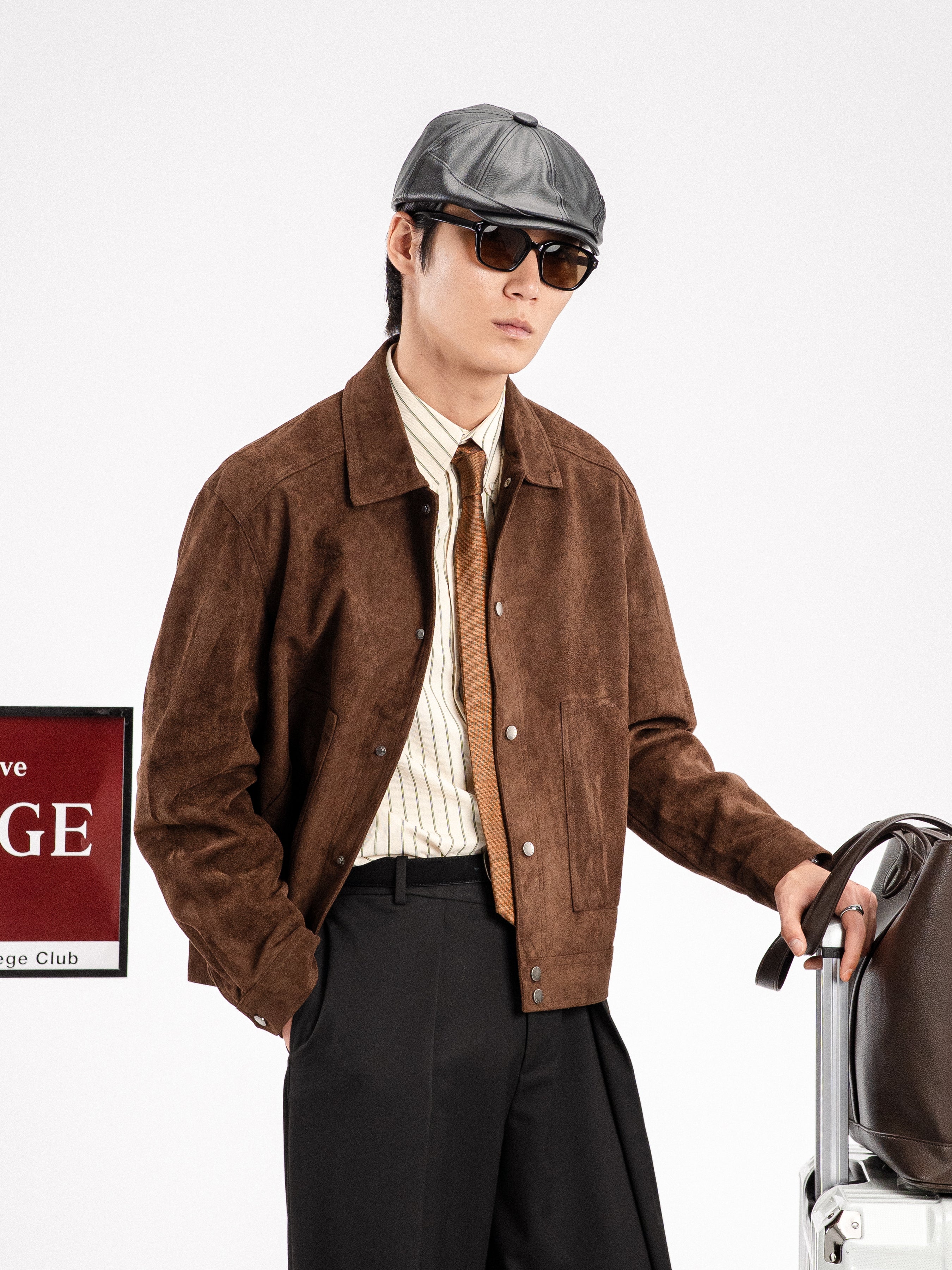 Man in brown suede jacket, striped shirt, tie, and cap with suitcase, stylish men's apparel