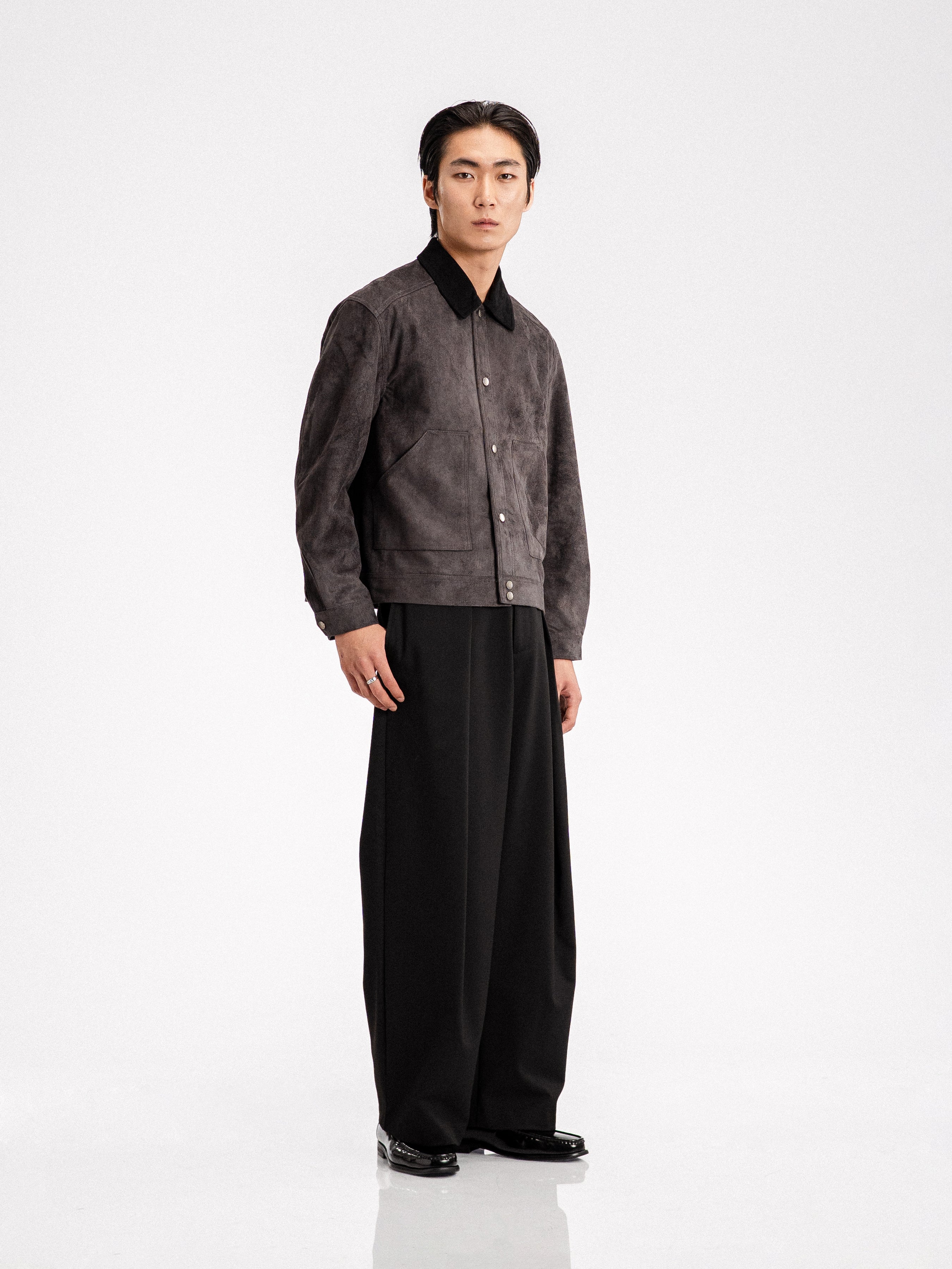 Men's gray suede jacket with black collar, paired with wide-leg trousers and loafers for stylish formal wear.