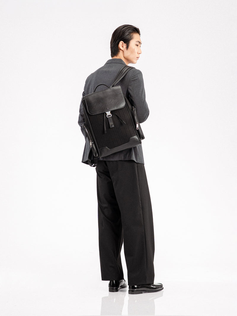 Man in formal suit with black leather backpack, stylish men's apparel and loafers