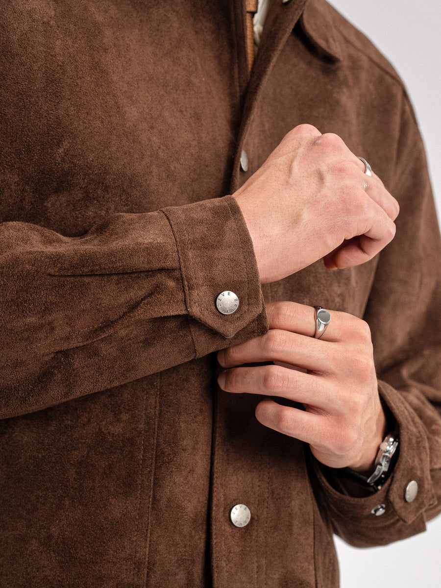 Brown suede men's jacket with silver buttons, styled with rings and watch for smart casual look