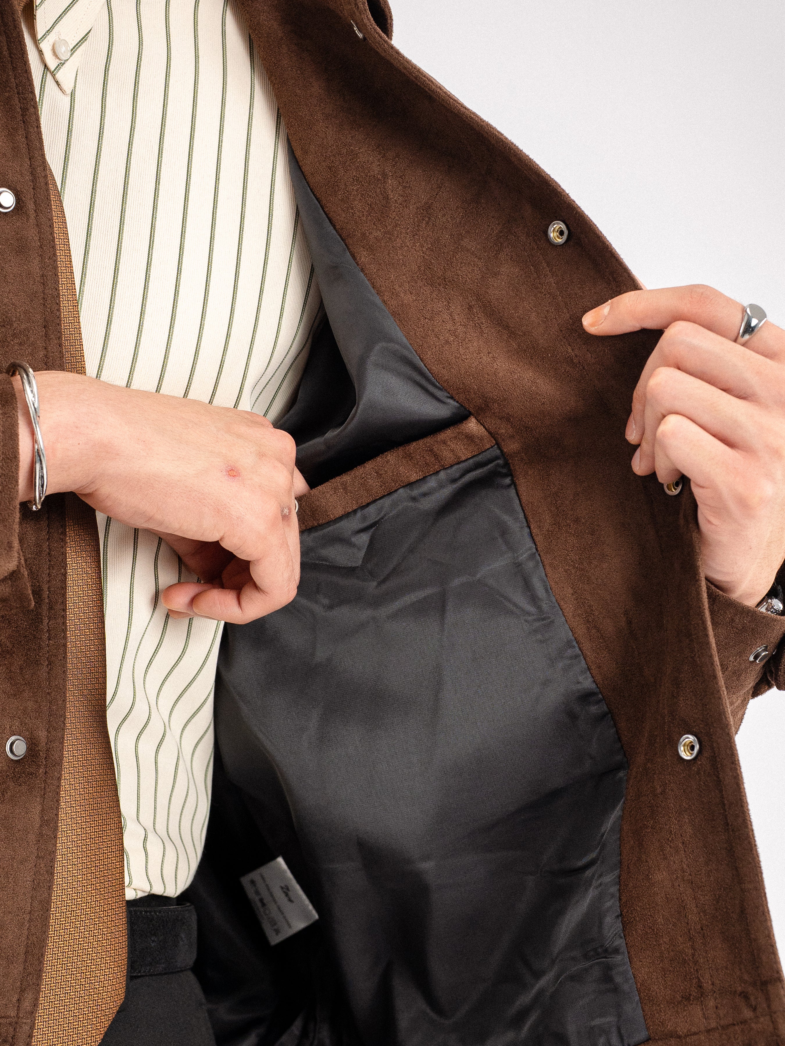 Brown suede men's jacket with striped shirt and patterned tie, stylish formal wear