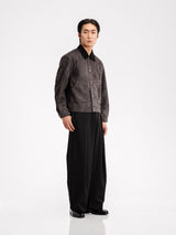 Men's gray suede jacket with black collar, paired with wide-leg trousers and loafers for stylish formal wear.